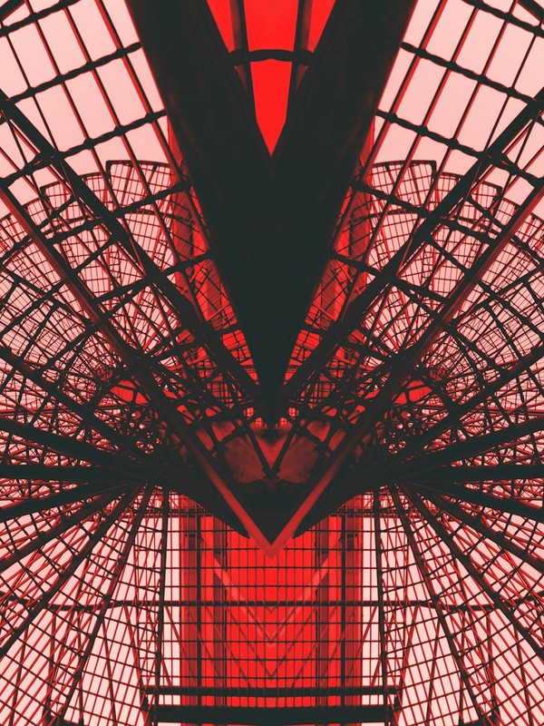 Abstract view of a red geometric architectural structure, showcasing modern design and symmetry.